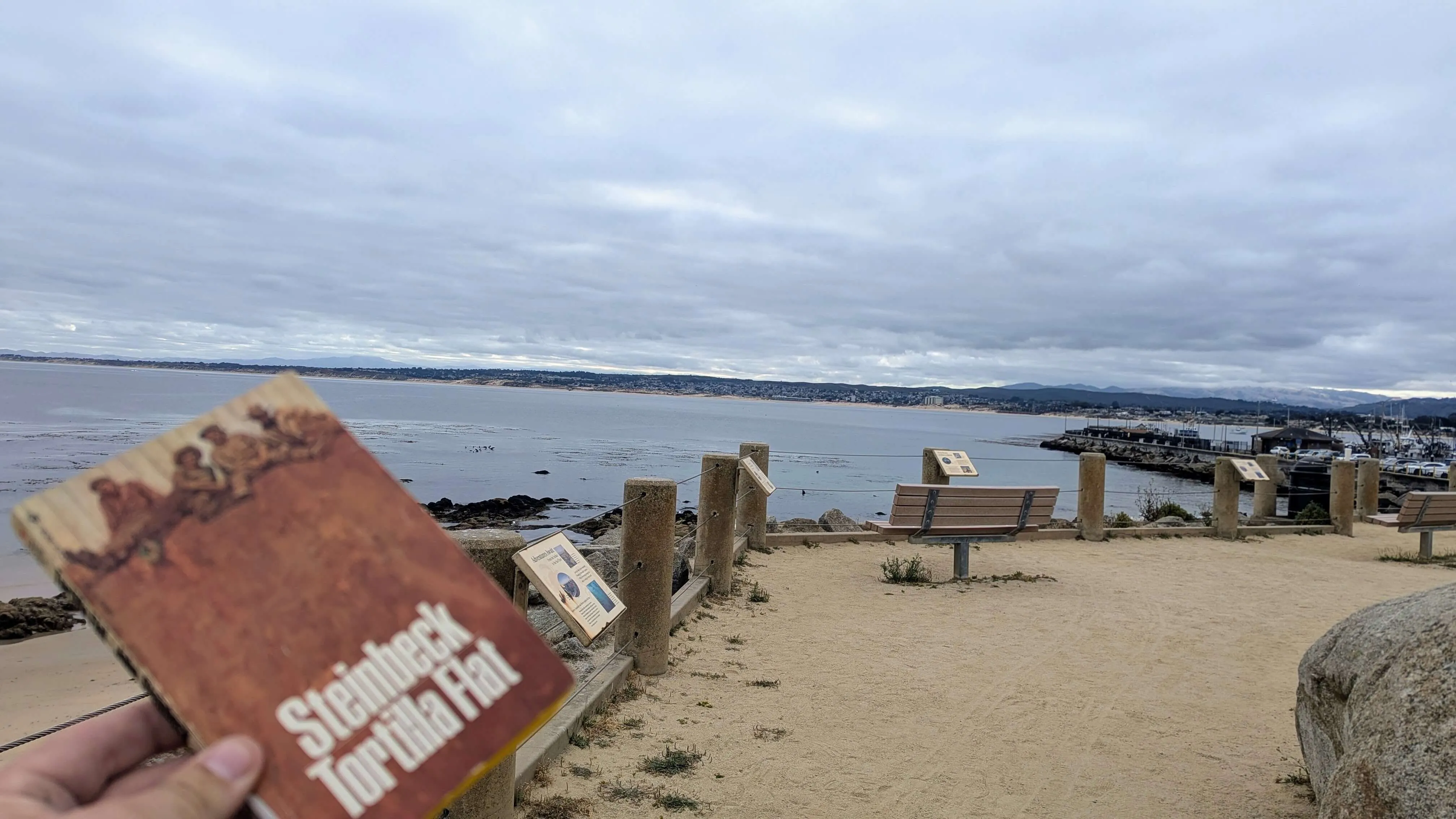 Tortilla Flat book in forground with Monterey Bay in the background